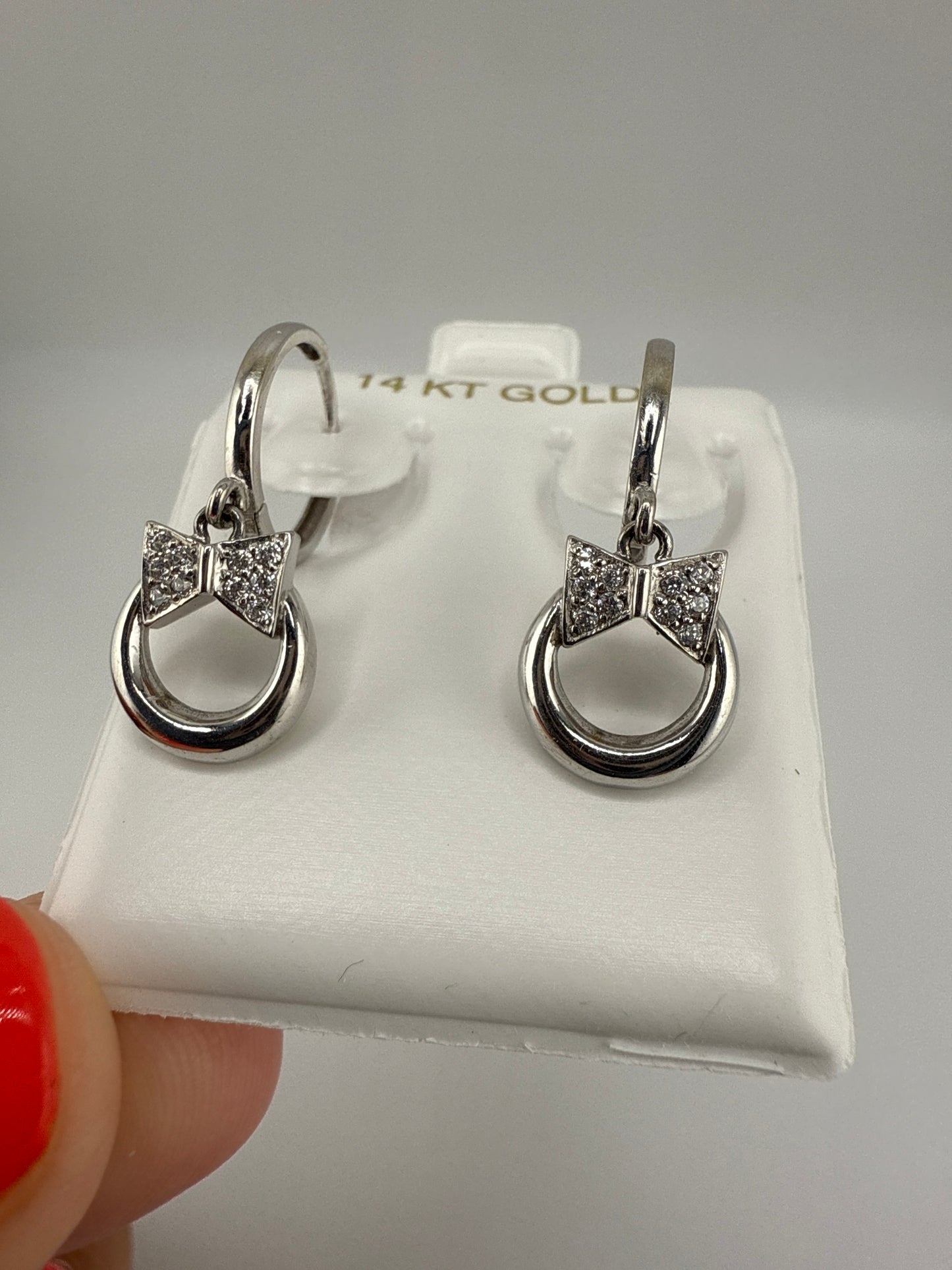 14k white and zirconia bow-tie huggie hoops