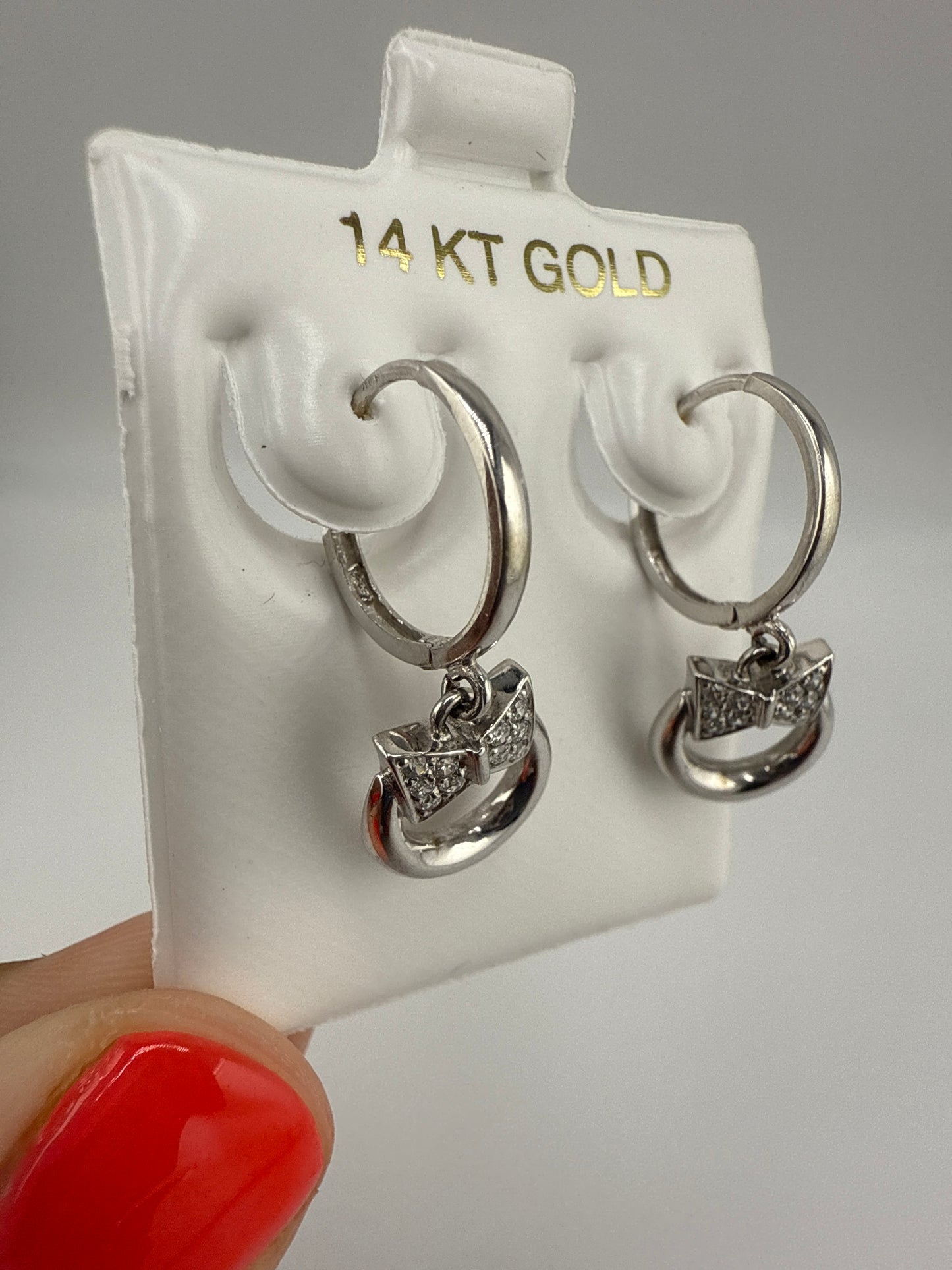 14k white and zirconia bow-tie huggie hoops